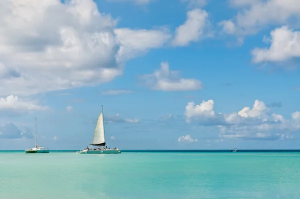 Idyllic blue beach with boats, Aruba island - Caribbean sea