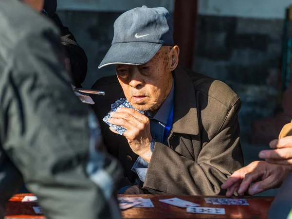 Elderly Chinese men playing cards in a park in Beijing