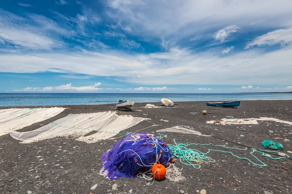 Fishing nets drying on the black beach