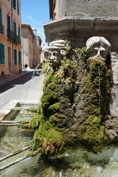 Stone heads and fountain on the corner of  Eglise De Tourves