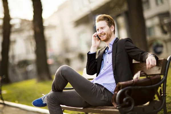 Young man with telephone on bench