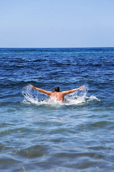 man swims in sea