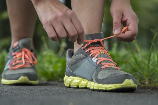 Running man tying shoelaces