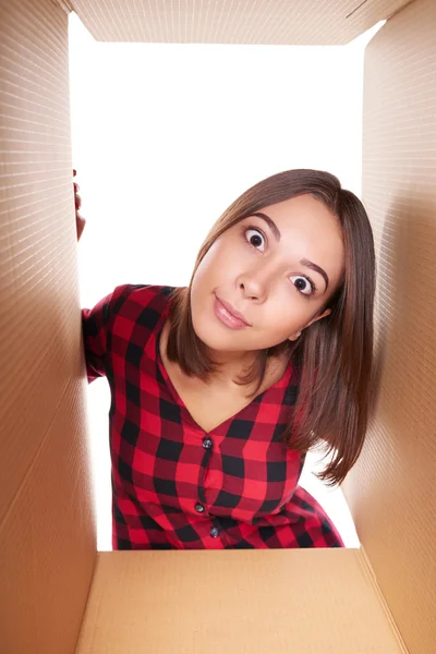 Girl opening a carton box and looking inside