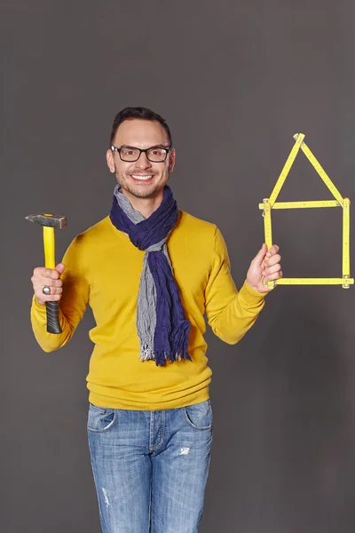 Man with hammer showing house frame concept