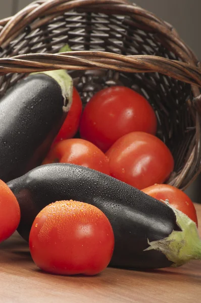 Tomatoes and eggplants with a basket
