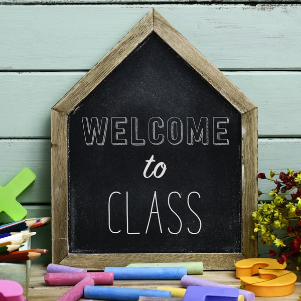 Text welcome to class in a house-shaped chalkboard