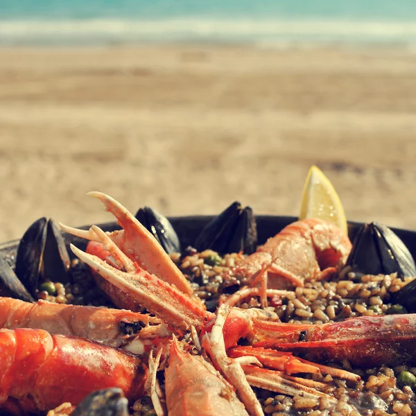 Spanish paella on the beach, with a retro effect