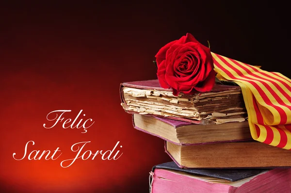 Books, red rose and the text Felic Sant Jordi, Happy Saint Georg