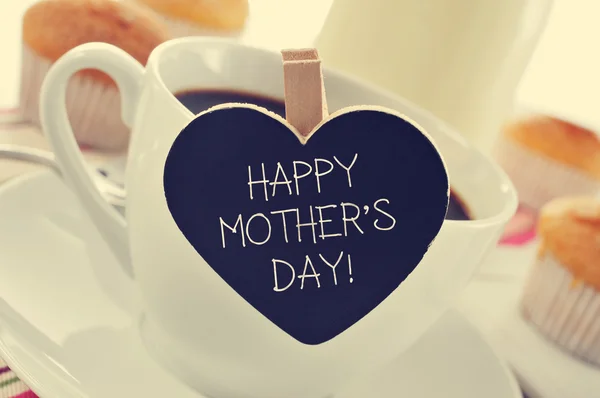 Breakfast and happy mothers day written in a heart-shaped blackbd