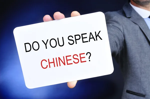 Man showing a signboard with the question do you speak chinese?