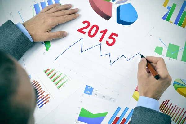 Businessman observing a chart with an upward trend during 2015