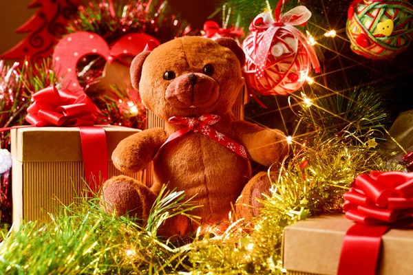 Teddy bear and gifts under a christmas tree