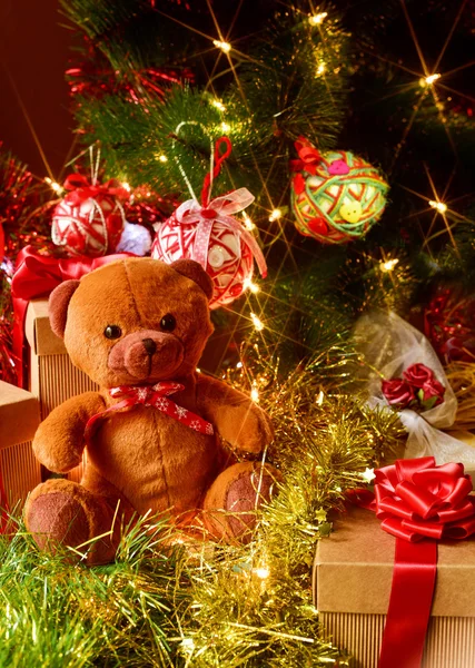 Teddy bear and gifts under a christmas tree