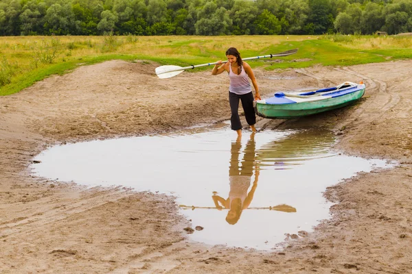 Girl and kayak in a small puddle