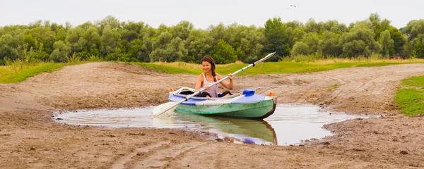 Girl and kayak in a small puddle