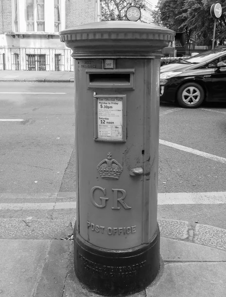 Red mail box in London in black and white