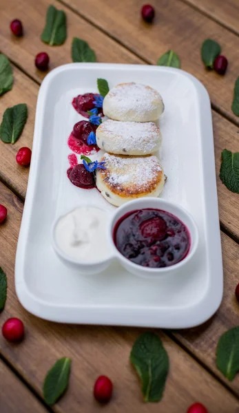 Cottage cheese pancakes with sour cream and berry sauce