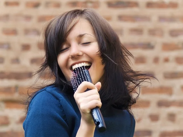 Girl sing into hair brush