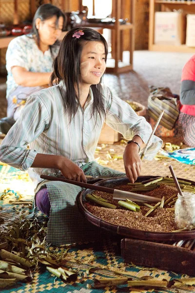 Young women making handmade cigarettes