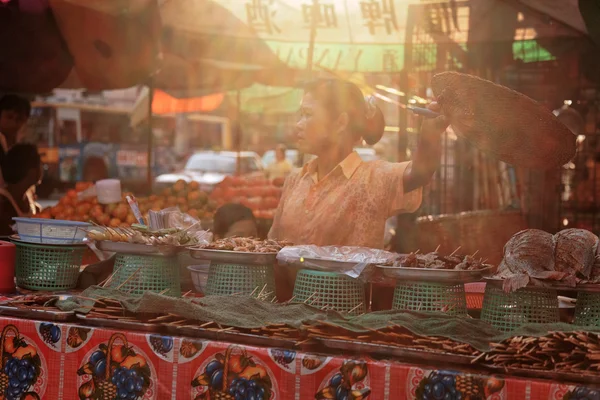 Burmese woman selling fried sausages