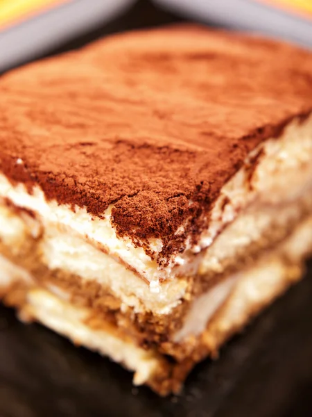 Tiramisu cake in black plate