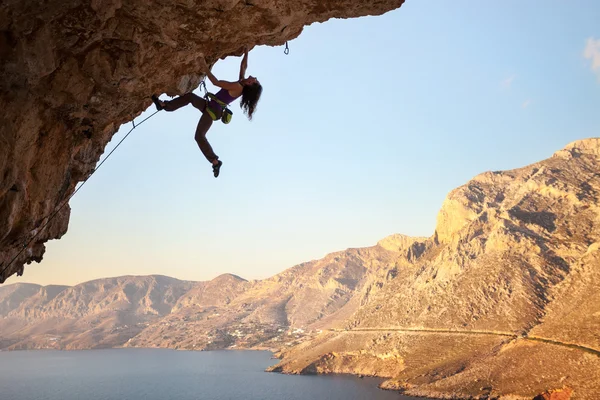 Female rock climber on overhanging cliff, Kalymnos Island, Greece