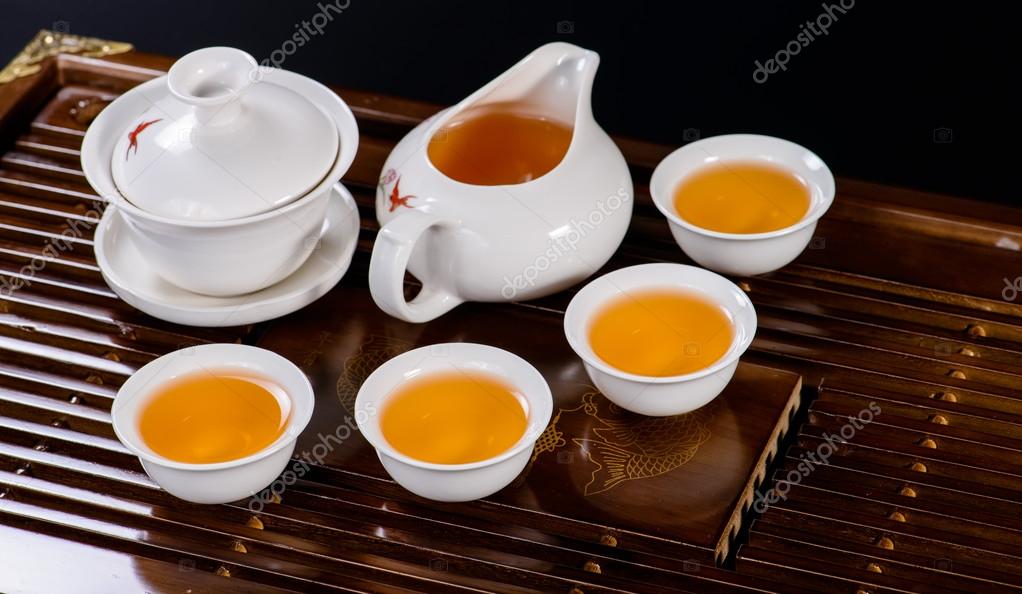 Chinese tea service cup of hot green tea, closeup, on black bac