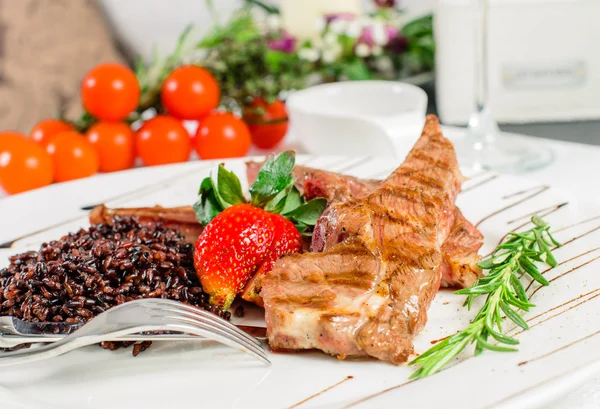 Hot dish of mutton ribs, brown rice, decorated with fresh strawb