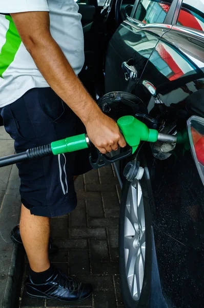 Man fills up his car with a gasoline at gas station