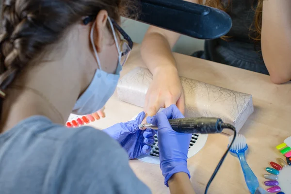 Closeup of manicurist at work in the salon nail (shallow DOF; co