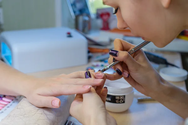 Closeup of manicurist at work in the salon nail (shallow DOF; co