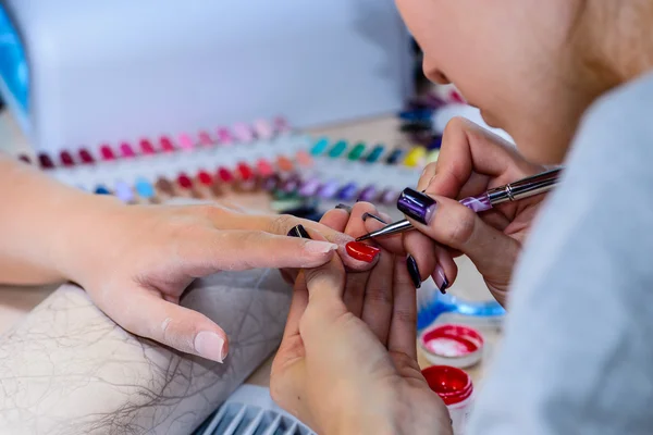 Closeup of manicurist at work in the salon nail (shallow DOF; co