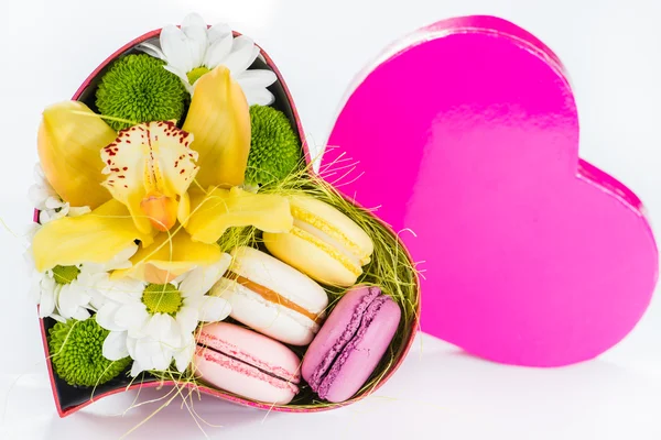 Closeup of gift box with flowers and macaroon cake in the shape