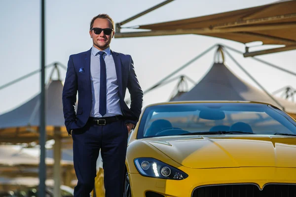 Successful yang businessman in yellow cabrio car