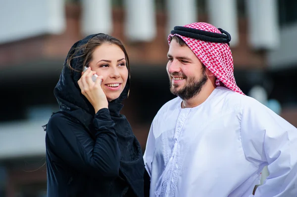 Moderm Arabic couple poses outdoors.