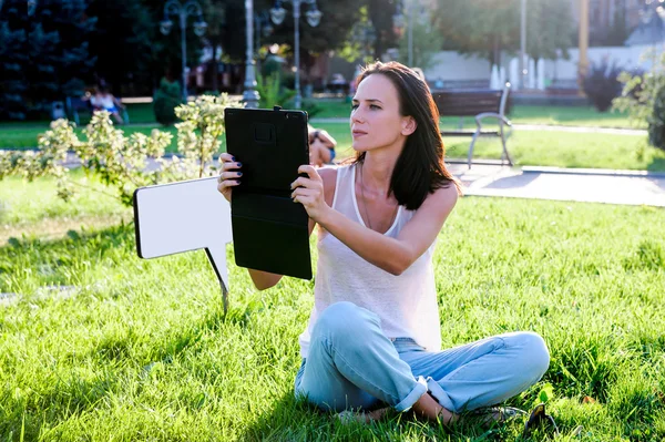 Yang and beautiful  woman poses outdoor with tablet computer.