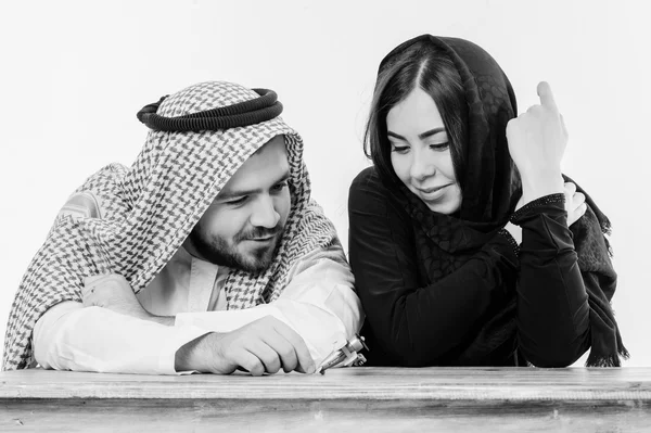 Middle eastern way dressed young couple playing with toy plane.