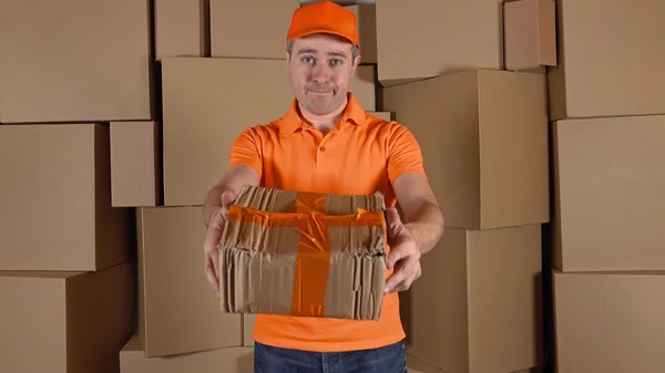 Courier in orange uniform delivering damaged parcel to customer. Brown cartons background. Flaw and unprofessional work concepts