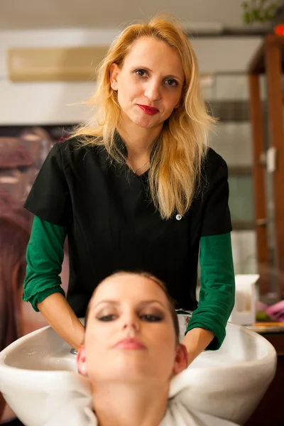 Hairdresser making hair treatment to a customer in salon