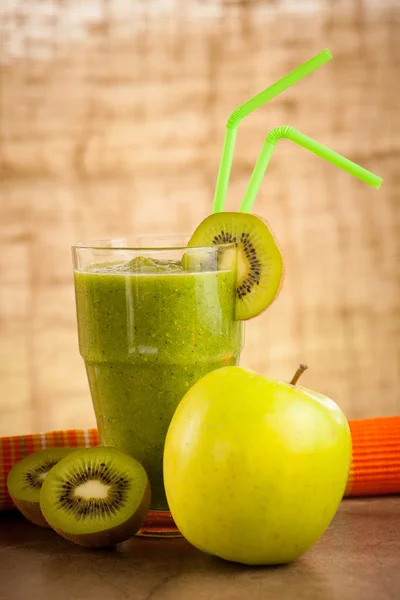 Healthy green Smoothie served in a glass decorated with two colo