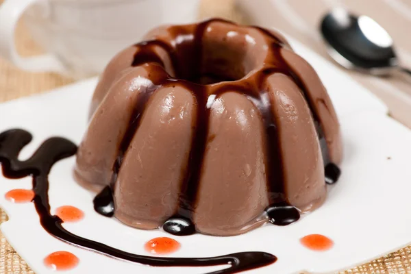 Chocolate pudding with chocolate dressing on white plate