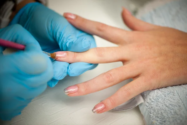 Making hand nails in a professional hand care salon - manicure