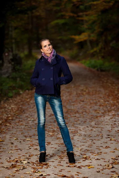 Blog style pretty young woman on a walk in forest on late autumn