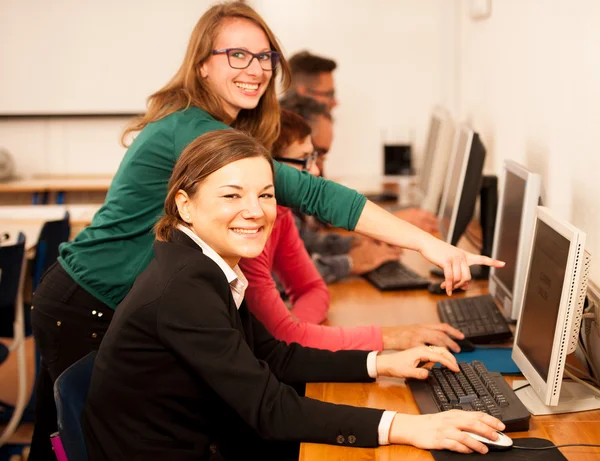 Group of adults learning computer skills. Intergenerational tran