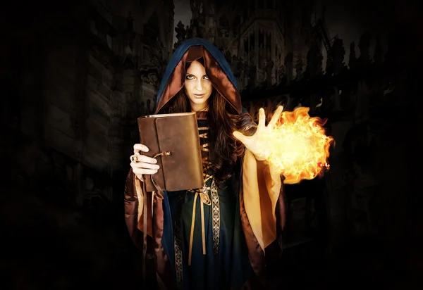 Halloween witch holding magical book of spells making magic