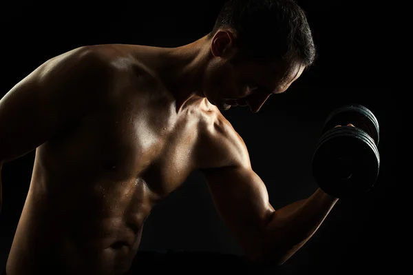 Silhouette of young muscular fitness man on black