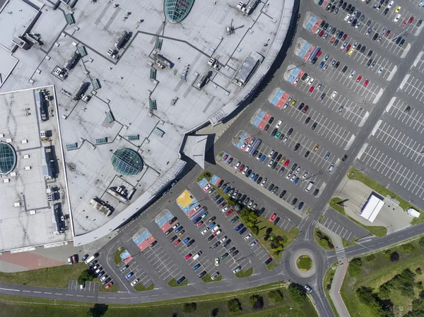 Supermarket roof and many cars in parking, viewed from above.