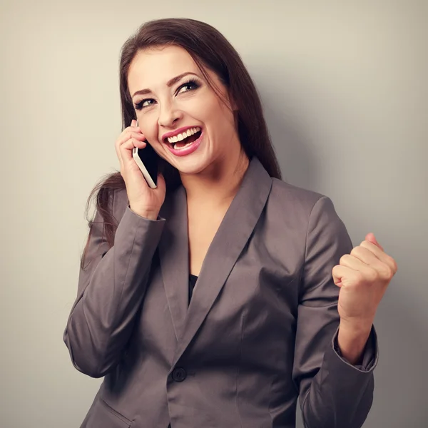 Happy business successful excited woman talking on mobile phone