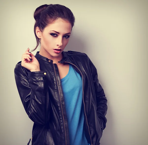 Sexy young makeup model posing in fashion black leather jacket.